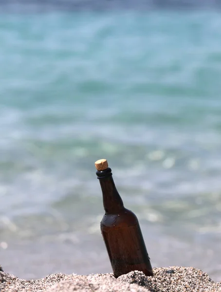 Bottle with message on the beach by the sea