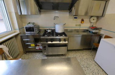 Fırınları ve paslanmaz çelik mobilyaları olan aşçıları olmayan donanımlı bir sanayi mutfağının içinde.