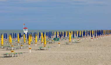 Avrupa 'daki Corona Virüsü salgını nedeniyle plajda çok az turist bulunan kapalı güneş şemsiyeleri.