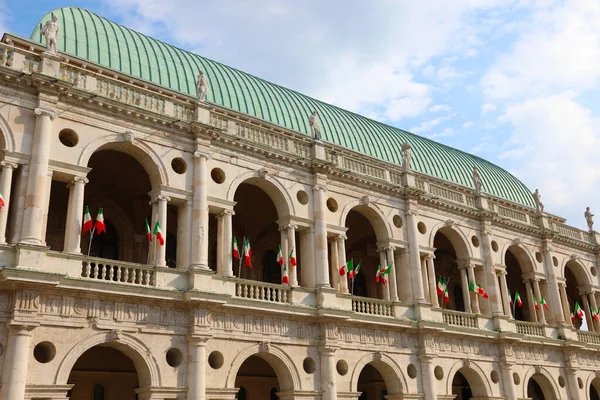 建築家アンドレア パッラーディオによって設計された歴史的建造物バジリカ パラディアナと呼ばれるビチェンツァ市と多くのイタリアの国旗 — ストック写真