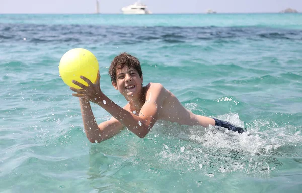 Νεαρό Αγόρι Παίζει Μια Μπάλα Στη Θάλασσα Καλοκαίρι — Φωτογραφία Αρχείου