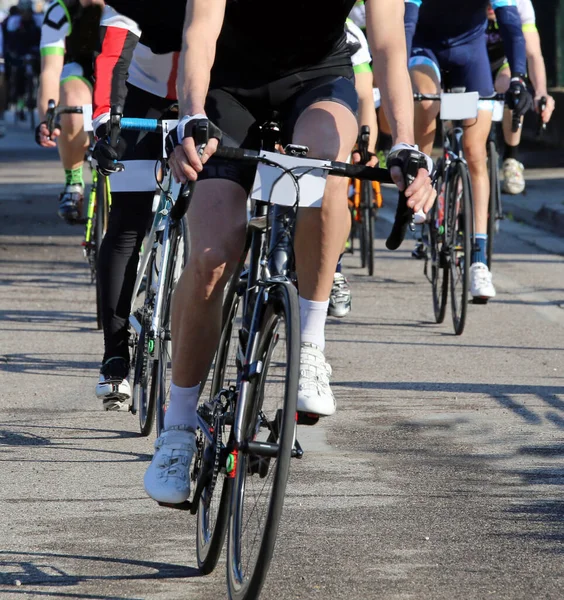 muscular legs of cyclists pedaling on bicycles during the road cycling race