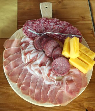 mixed cold cuts from the wooden cutting board in the Italian farmhouse