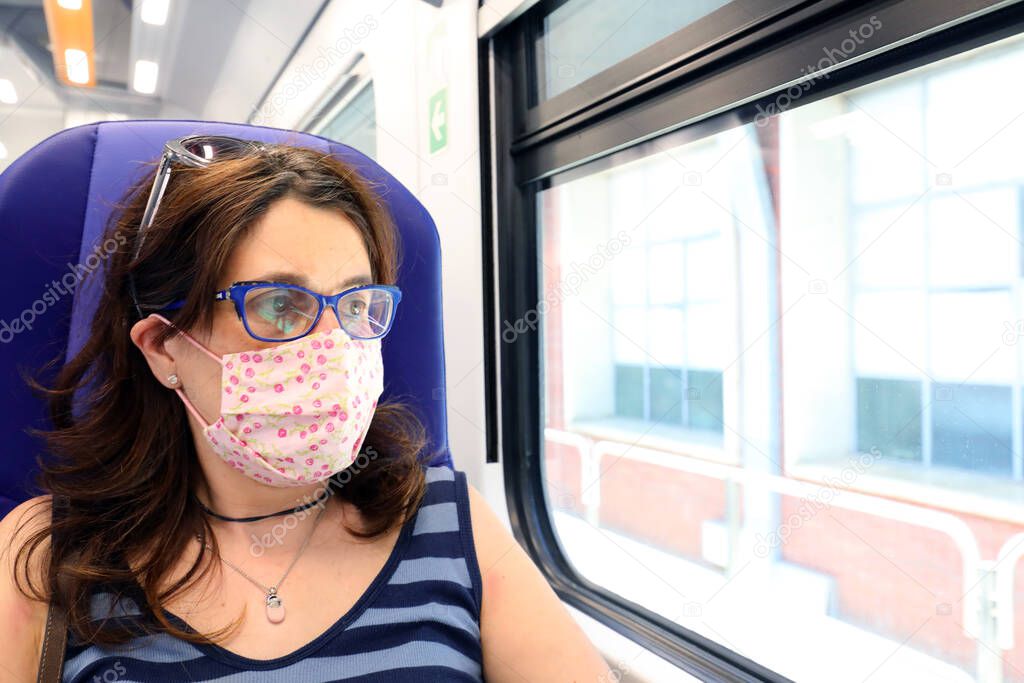 woman with surgical mask travels by train during Corona Virus emergency