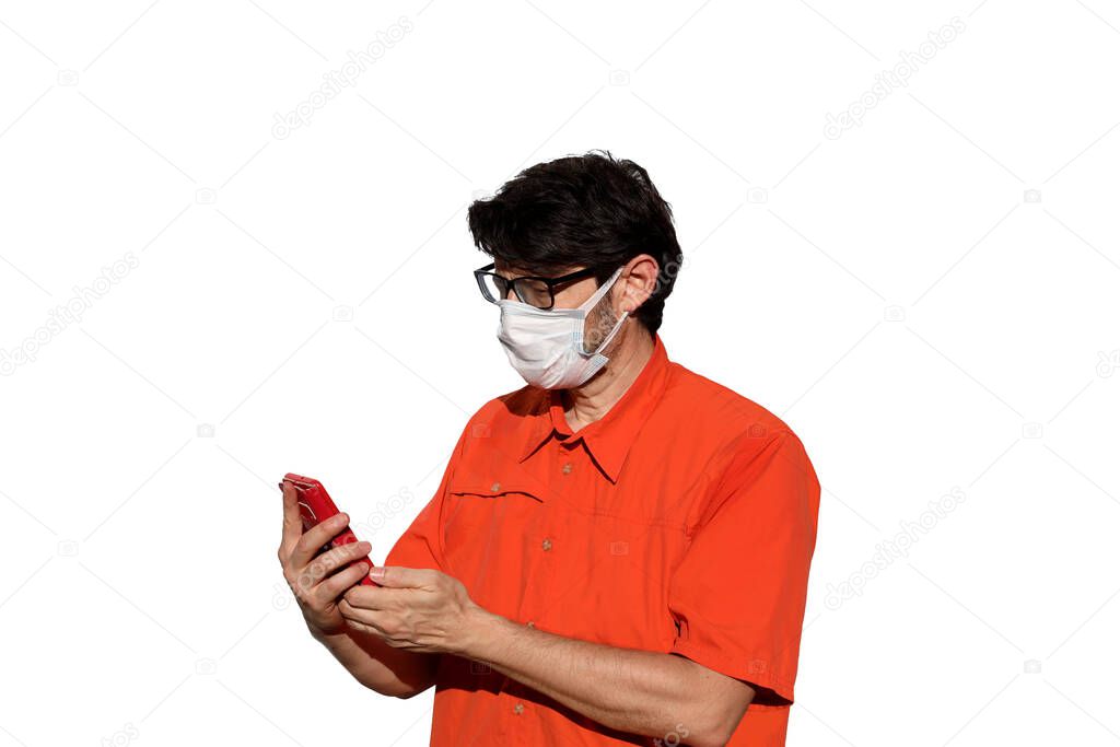 man with orange shirt and surgical mask while using smarthpone to send messages on a white background