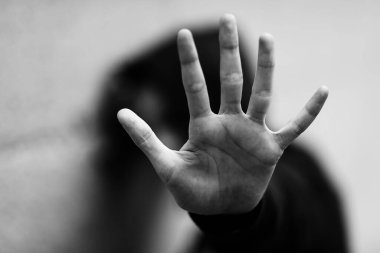 Siyah ve beyaz etkisi olan bir taciz sırasında kendisini saldırgandan korumak isteyen küçük kızın eli.