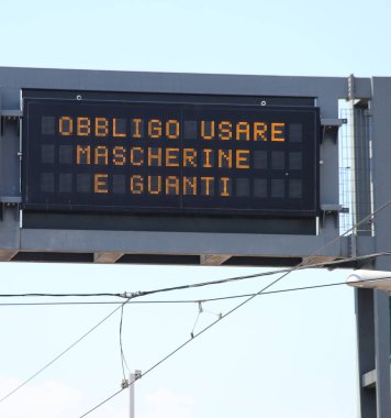İtalyanca yazılmış maske ve eldiven kullanmak için zorunlu göstergelere sahip büyük değişken ileti paneli