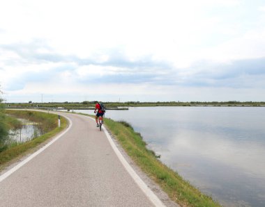 Yazın Venedik gölü gezisi sırasında bisiklet yolundaki çocuk.