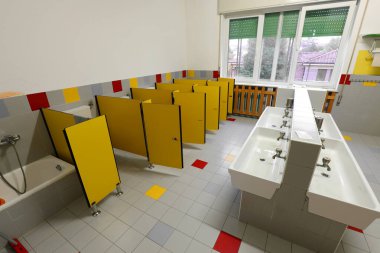 Sarı kapılı ama koronavirüs salgını yüzünden evde kalan çocuklar olmadan anaokulu tuvaletinde.
