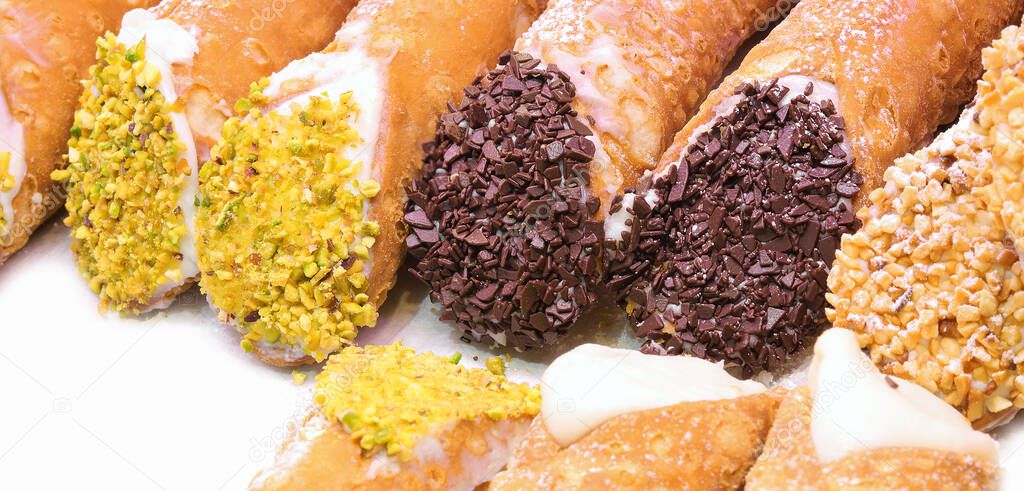 many pastries called CANNOLI in Italian Language with pistachio and chocolate