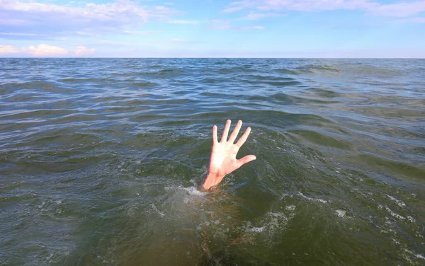 hand of the person asking for help while drowning in the middle of the sea