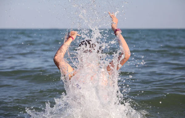 幸せな少女は笑顔で海で遊ぶダイビングマスクで水でスプラッシュを作る — ストック写真