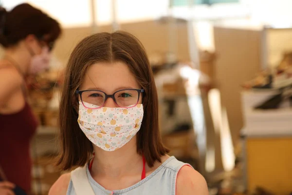 地元の市場で買い物をしながら外科用マスクをした少女が笑顔で — ストック写真