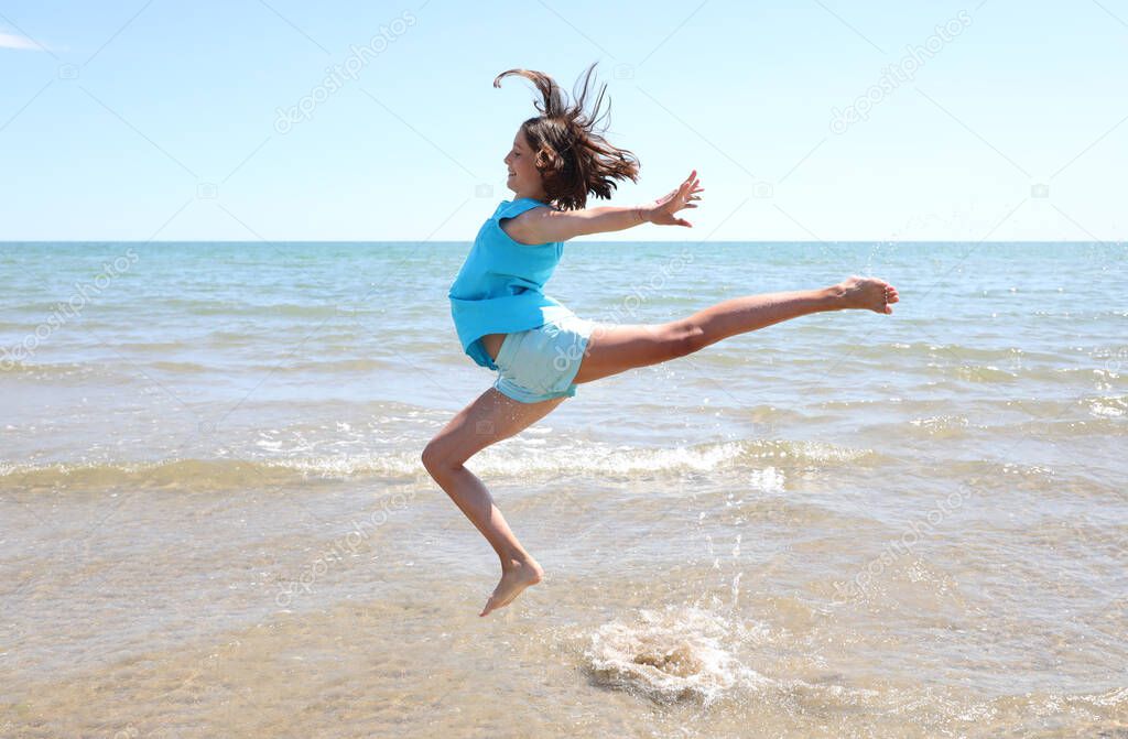 high jump of a very happy young athlete during training on the seashore in summer