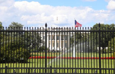 Washington, DC, ABD - 26 Ağustos 2025: Metal güvenlik kapısı Beyaz Saray ve büyük bayrağı koruyor
