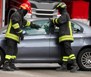 Kırık olduğu için arabanın camı kırıldığında itfaiyeciler gidip arabada mahsur kalan yaralıyı kurtarırlar.
