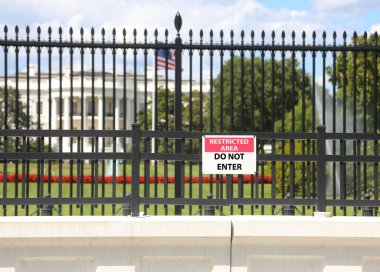 Washington, DC, ABD - 26 Ağustos 2025: Önünde alarm işareti olan büyük Amerikan bayrağı ve çiti olan beyaz ev