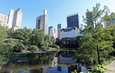 Central Park ve gölün sularındaki yansıma ve New York 'taki birçok gökdelen.