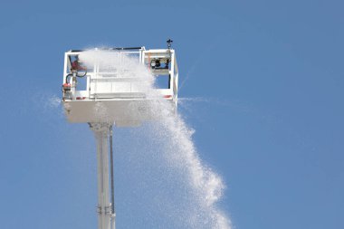 İtfaiye arabasının entegre yangın musluğuyla dolu sepeti su ve kendi kendine söndüren köpük maddesiyle birlikte aşağıdan ve mavi gökyüzünden görüldü.