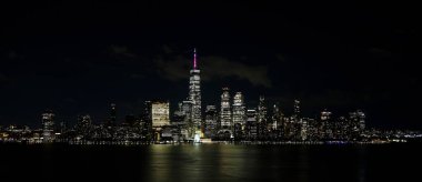Aşağı Manhattan binalarının ve New Jersey 'deki gökdelenlerin duygusal gece manzarası ve Hudson Nehri' nin sularındaki şehir ışıklarının yansıması.