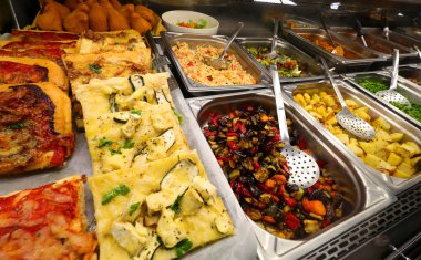 buffet of various prepared Italian dishes including pasta pizza and vegetables