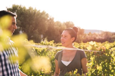 Çekici esmer ve birbirine bakarak ve güneşli bir günde konuşmak üzüm bağları erkekte