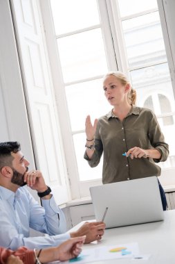 Yeşil tişörtlü daimi bir resepsiyon ile bu bir adam ararken eliyle işaret üstünde a laptop önünde kadın