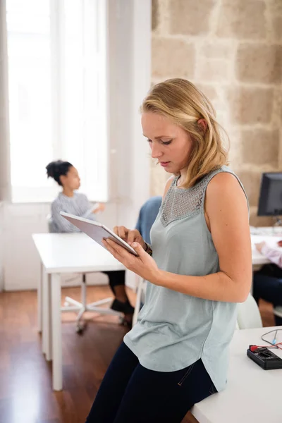 Mujer Rubia Con Top Azul Apoya Sobre Escritorio Sosteniendo Una — Foto de Stock