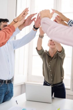 Grup erkek ve kadın kolları olan bir zaferini kutluyor, bir toplantı odası masa etrafında yükseltilmiş