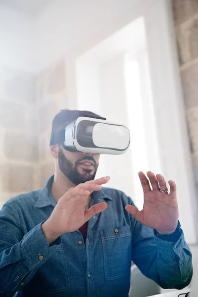 男子拿着他的手在他的脸面前与一对虚拟现实眼镜 — 图库照片