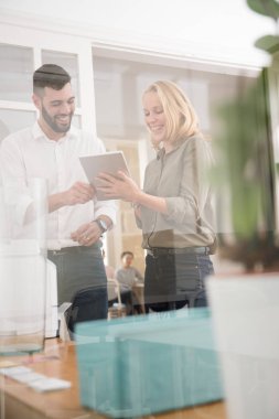 Erkek ve kadın o onlar are her ikisi de seyir, bir pc tablet tablet vasıl işaret ediyor tutar gibi gülüyor