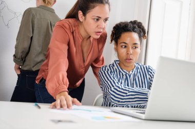 Üç iş kadınları bir office çalışan bir vardır onu geri iki için bir dizüstü bilgisayar arayan kadın oturmuş