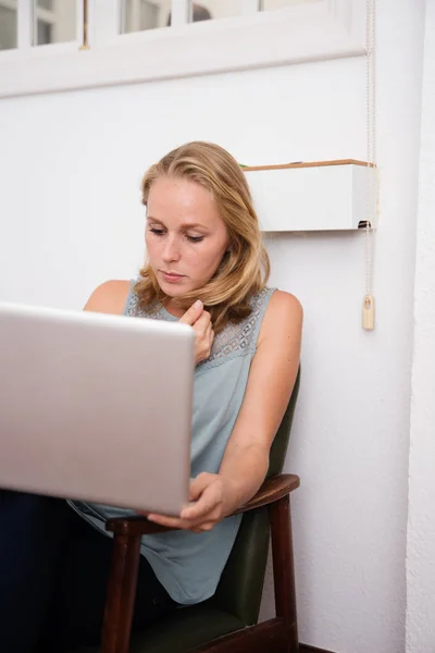 Kobieta Patrząc Laptopie Siedząc Fotelu Biurze Przy Ścianie — Zdjęcie stockowe