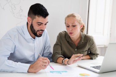 Kadın ve adam bir masada oturan ve belgeleri önlerinde bakmak ve içeriği tartışmak