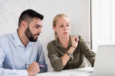 Onlar konsantre gibi bir ofis ve dizüstü ekran noktada bir masanın arkasında oturan kadın ve erkek arıyorum dalgın