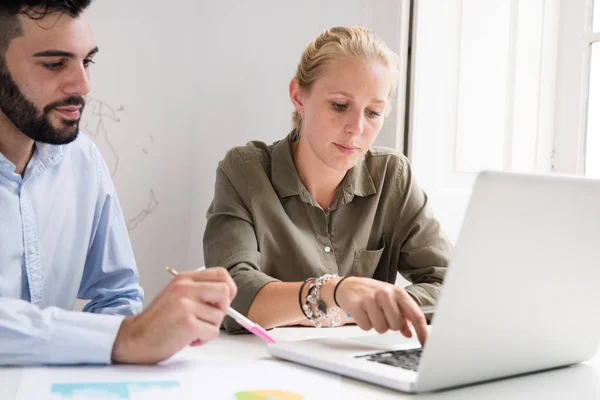 Man Sitting Desk Pointing Laptop Pen Woman Types Keyboard — Stock Photo, Image