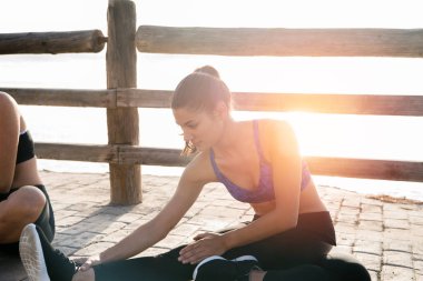 Mavi ürün top beach germe yanındaki bir kaldırımda oturan ve çerçeve yakından öne eğilerek bir kadın