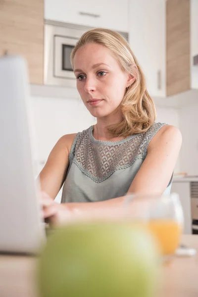 Kobieta Pochylenie Tyłu Pisania Laptop Jak Ona Siedzi Przy Stole — Zdjęcie stockowe
