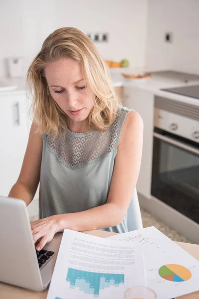 Mulher Sentada Uma Mesa Uma Cozinha Digitando Laptop Enquanto Ela — Fotografia de Stock