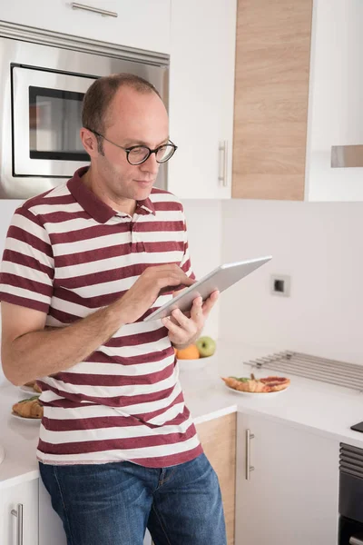 Man Leaning Kitchen Counter Holds Tablet — Stock Photo, Image