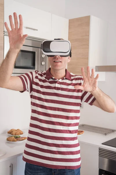 男子站在厨房 他的手 因为他戴着一对虚拟现实眼镜 — 图库照片