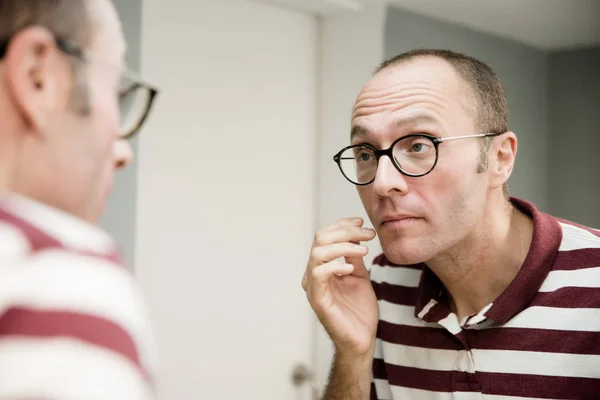 Reflective Image Man Looking Mirror Raising His Eyebrows Touches His — Stock Photo, Image