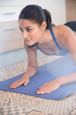 Kadının bir itme yapması kadar mavi bir mindere ellerini yere düz ve kafasını yukarı