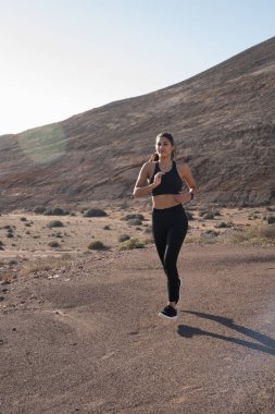 Arkasında bir dağ ile çölde çalışan kadın