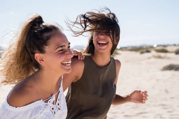 그들은 해변을 웃음으로 바람이 소녀의 머리를 불고있다 — 스톡 사진