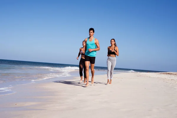 Människor Jogging Bredvid Vattenlinjen Som Kör Stranden Klädda Träningskläder — Stockfoto