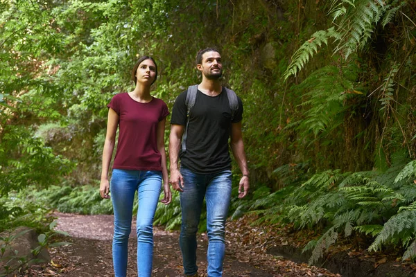 Pareja joven caminando junto a los árboles — Foto de Stock