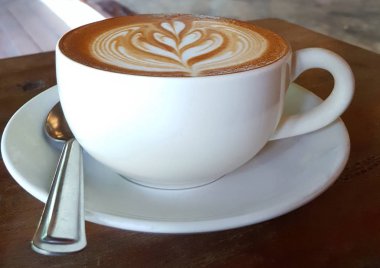  Ahşap masada fincan sıcak kapuçino kahve. 