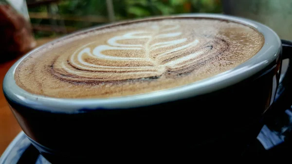 木製のテーブルの上のカップにホットカプチーノコーヒー エスプレッソコーヒーと混合カプチーノ ミルクは細かい泡とミルク加圧蒸気です いつかコーヒーにシナモンパウダーやココアパウダーを添えて — ストック写真
