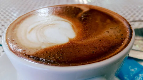 木製のテーブルの上のカップにホットカプチーノコーヒー エスプレッソコーヒーと混合カプチーノ ミルクは細かい泡とミルク加圧蒸気です いつかコーヒーにシナモンパウダーやココアパウダーを添えて — ストック写真